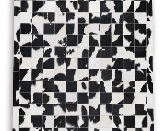 Può includere: Un tappeto rettangolare con un motivo a scacchiera in bianco e nero. Il tappeto è realizzato in pelle di mucca, con ogni quadrato che presenta un motivo unico di pelliccia bianca e nera. Il design generale è un pezzo audace e moderno.