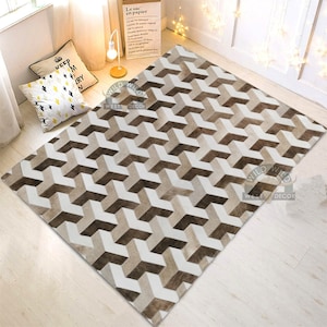 May include: A geometric patterned cowhide rug with a white and brown color scheme. The rug has a 3D effect and is made of natural cowhide.