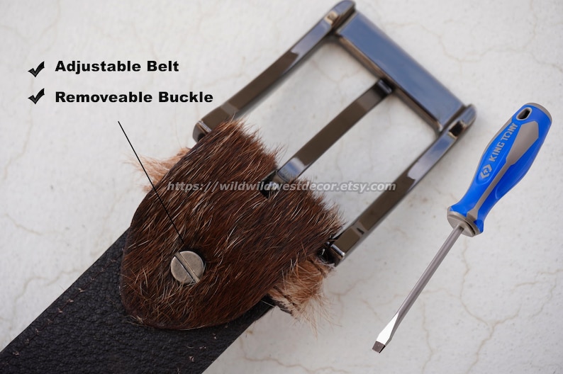 May include: A close-up of a black belt with a removable buckle and a brown fur accent. A blue and silver screwdriver is next to the belt. The text "Adjustable Belt" and "Removable Buckle" are visible.