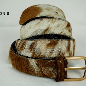 May include: A set of three ceramic mugs with a speckled, matte finish. Each mug features a different color: light blue, cream, and gray. The mugs have a simple, modern design and a comfortable handle.