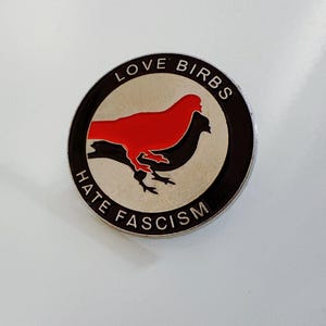 Broche de paloma con la frase "Los pájaros del amor odian el fascismo"