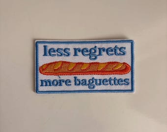 Light blue iron‑on patch “less regrets more baguettes” – funny embroidered applique for jackets, jeans & bags