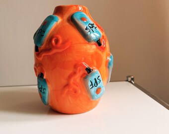 Handmade orange ceramic vase with SPF bottle details – playful summer pottery, bright unique home decor accent