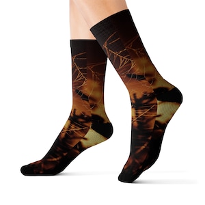 Puede incluir: Calcetines deportivos con un diseño abstracto marrón oscuro y amarillo. Los calcetines tienen talones y dedos negros, y una parte superior de malla negra. El diseño parece ser un primer plano de una planta o un árbol.