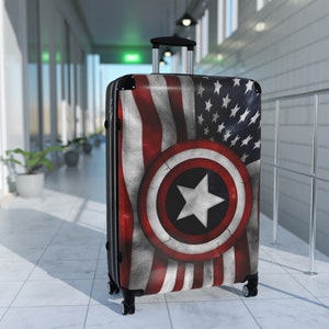May include: A black suitcase with a red, white, and blue American flag design and a large white star in a circle on the front.