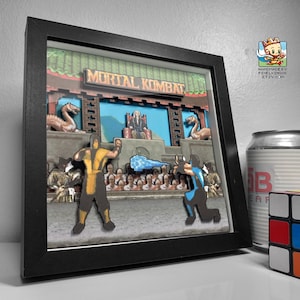 May include: A framed 3D pixel art scene of the Mortal Kombat video game. The scene features two characters fighting, one in yellow and one in blue. The background includes a throne with a figure sitting on it.