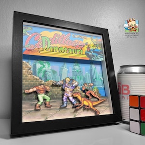 Puede incluir: Un diorama 3D enmarcado en negro del clásico juego de arcade 'Cadillacs and Dinosaurs' de Capcom. El diorama presenta personajes del juego, incluido un dinosaurio, en un escenario de ciudad.