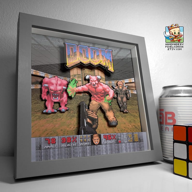 Angled view of a grey-framed classic DOOM layered shadow box featuring the first-person shotgun and demons.