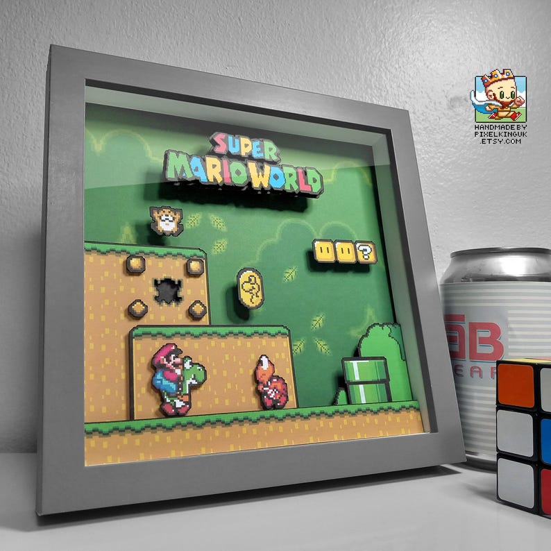 Angled view of the Super Mario World Yoshi’s Island shadow box in a grey frame, showing the green platform scene with Yoshi and a red enemy.