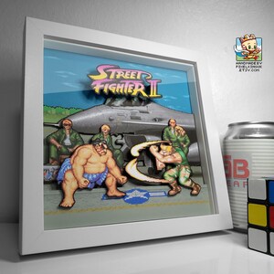 Angled view of the framed E. Honda versus Guile shadow box showing the depth between the layered artwork.