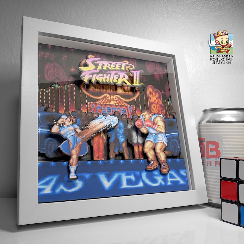 Angled view of the framed Chun-Li versus Balrog shadow box showing the depth between the layered artwork.