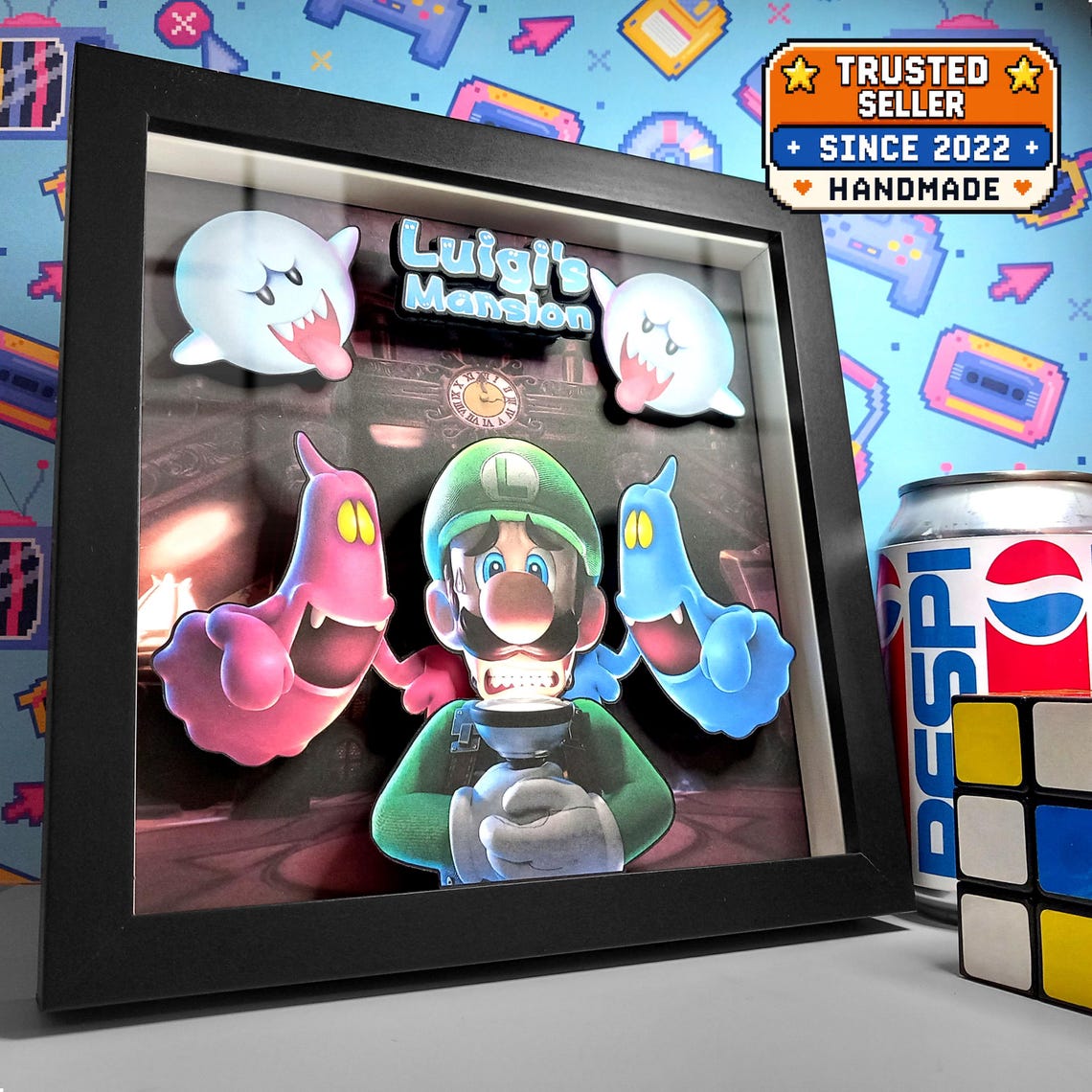 Black-framed Luigi's Mansion shadow box with Luigi, his Poltergust and colourful ghosts