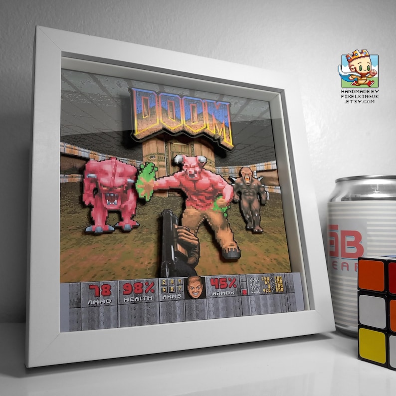 Angled view of a white-framed classic DOOM layered shadow box with the first-person demon battle scene.