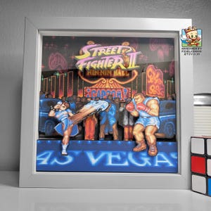 Front view of the framed Street Fighter II shadow box showing Chun-Li versus Balrog on the Las Vegas stage.