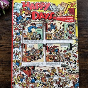 Könnte beinhalten: Ein Vintage-Comic-Cover von "Happy Days" mit farbenfrohen Illustrationen und Text. Das Cover zeigt Zeichentrickfiguren, den Titel "Happy Days" in großen roten Buchstaben und den Text "One hundred years of COMICS".