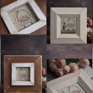 May include: Four framed cross-stitch artworks with Easter themes. Each frame is square, with a light-colored inner frame and a darker outer frame. The cross-stitch designs feature bunnies, floral arrangements, and the text "Happy Easter".