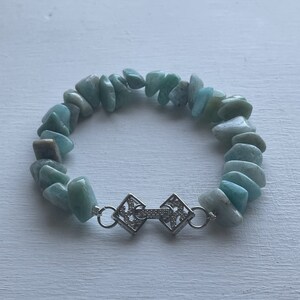 Peut inclure: Un bracelet en pierres précieuses bleu clair avec un fermoir argenté. Le bracelet est composé de petites pierres de forme irrégulière.