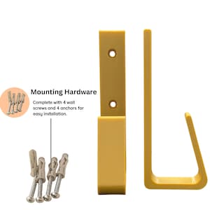 May include: Mustard-yellow wall-mounted hook and mounting hardware. The hook has a rectangular backplate with two screw holes and a curved hook. The hardware includes four wall screws and four anchors. Text reads "Mounting Hardware".