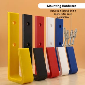May include: A set of colorful, L-shaped wall hooks in yellow, black, red, white, and blue. The image shows the hooks with mounting hardware, including screws and anchors. The hooks are designed for easy installation.