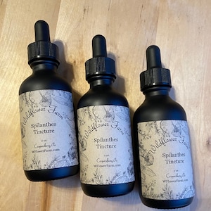 May include: Three 2-ounce bottles of Spilanthes Tincture from Wildflower Farm. The bottles are black with a brown label that says "Wildflower Farm" and "Spilanthes Tincture". The label also includes the text "Coopersbury Pa" and "WFlowerFarm.com".