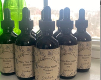 May include: Seven brown glass bottles with dropper tops and labels that read "Wildflower Farm White Pine Needle Tincture 2oz".