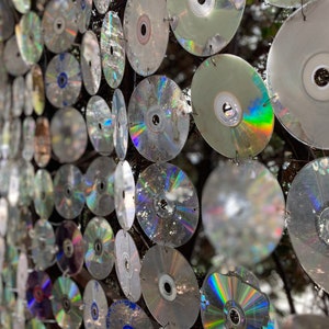 Peut inclure: Un mur recouvert de centaines de CD irisés, créant une mosaïque chatoyante et colorée.