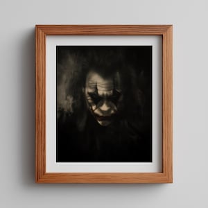 May include: Framed print featuring a portrait of a character with white face paint, black eye makeup, and red lipstick. The image is in black and white, with a dark background and a wooden frame.