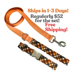 May include: Orange and black plaid dog collar and matching leash set. The collar has a silver buckle and the leash has a silver clip.