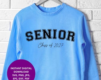 Könnte beinhalten: Ein hellblaues Sweatshirt mit Rundhalsausschnitt, das das Wort SENIOR in einer fetten schwarzen College-Schrift zeigt, darunter der Text Class of 2027 in einer dünnen Schreibschrift. Ein violetter Kreis zeigt den Text INSTANT DIGITAL DOWNLOAD SVG, PNG, JPG, EPS, DXF, PDF.