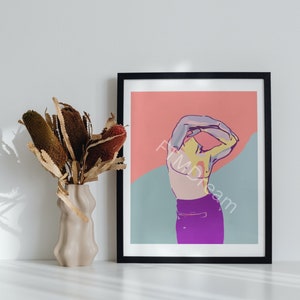 Puede incluir: Impresión artística abstracta en un marco negro. La obra presenta una figura con los brazos levantados, sobre un fondo rosa y azul. Un jarrón con flores secas se encuentra a la izquierda de la obra enmarcada.