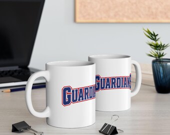 May include: Two white ceramic mugs featuring the word GUARDIANS printed in a bold, block-style font with dark blue lettering and a red outline. The text is positioned horizontally across the center of each mug.
