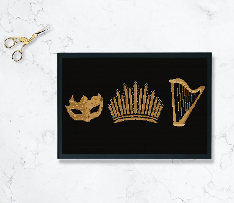 May include: A black framed print with three gold icons: a mask, a crown, and a harp. The icons are on a black background.