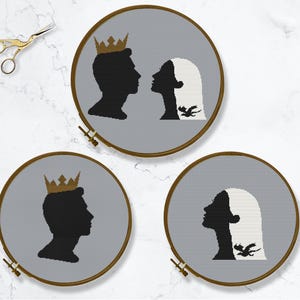 May include: Three embroidery hoops with gray fabric. Each hoop features a silhouette of a couple with a crown and a dragon. The couple in the top hoop is facing each other, the couple in the left hoop is facing right, and the couple in the right hoop is facing left.