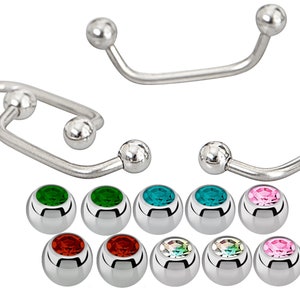 May include: A set of surgical steel body jewellery with a curved barbell design. The set includes a variety of coloured gem-encrusted balls for replacement.