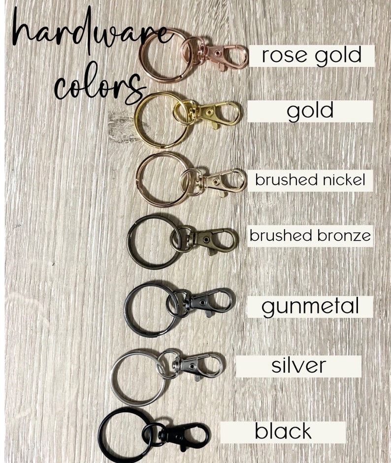May include: Hardware colours for keychains, shown as a series of key rings with different coloured clasps.  The colours are rose gold, gold, brushed nickel, brushed bronze, gunmetal, silver, and black.