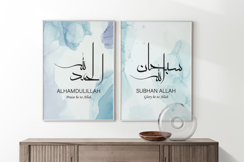 May include: Two framed prints with blue watercolor backgrounds and Arabic calligraphy. The text on the left print reads "Alhamdulillah" and "Praise be to Allah". The text on the right print reads "Subhan Allah" and "Glory be to Allah".