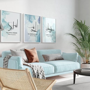 May include: Three framed prints with Arabic calligraphy and watercolor backgrounds. The prints feature the phrases "Allahu Akbar", "Alhamdulillah", and "Subhan Allah" in black calligraphy on a blue and white watercolor background.