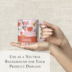 Pode incluir: Uma caneca de cer&acirc;mica branca com um design floral rosa e uma faixa vermelha na parte inferior. A faixa tem o nome "Cassidy" impresso em branco.