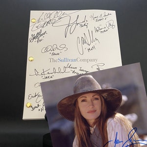 May include: A signed script from the TV show "The Sullivan Company" with several signatures, including the actors' names and roles. The script is on a white background with gold brads. A photo of a woman wearing a brown hat and a white shirt is in the background.