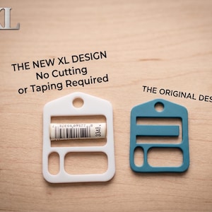 May include: A white XL design plastic fastener with a barcode label and a teal original design fastener. Text reads: XL, THE NEW XL DESIGN No Cutting or Taping Required, and THE ORIGINAL DESIGN. Both items feature a house-shaped top with a hole.