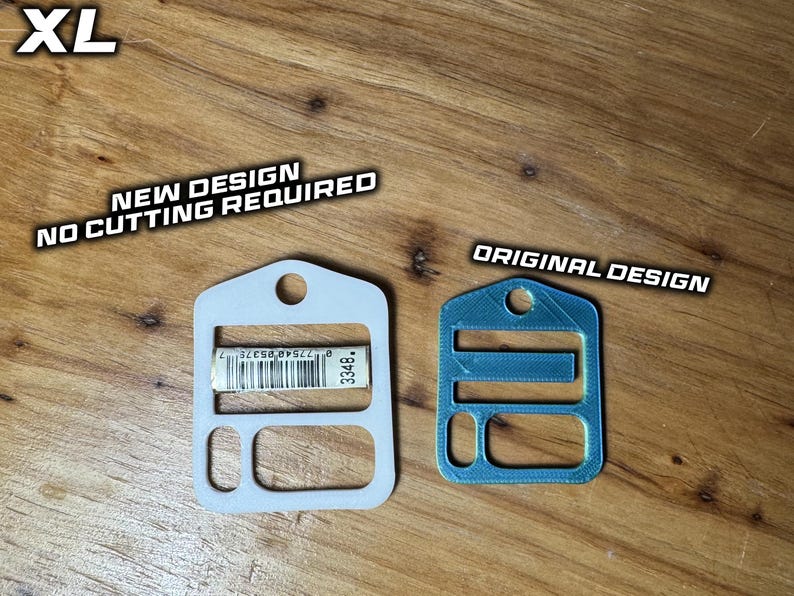 May include: Two flat, rectangular plastic components with rounded corners and a top hole. The left white component is labeled 'NEW DESIGN NO CUTTING REQUIRED' and features a barcode. The right blue component is labeled 'ORIGINAL DESIGN'.