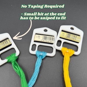 May include: Three white plastic embroidery floss bobbins with green, blue, and yellow thread. Each bobbin features a barcode label and a hole for hanging. Text reads: No Taping Required - Small bit at the end has to be sniped to fit.