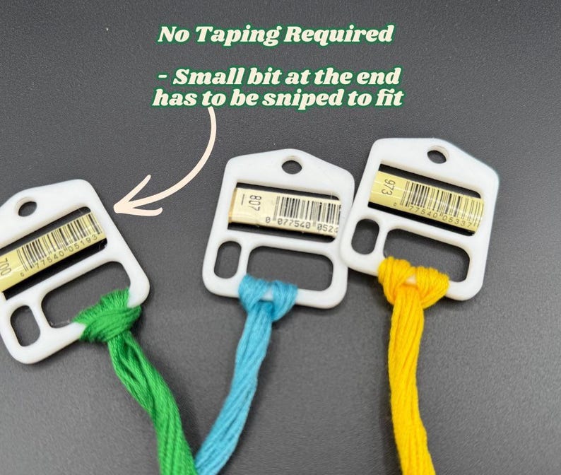 May include: Three white plastic embroidery floss bobbins with green, blue, and yellow thread. Each bobbin features a barcode label and a hole for hanging. Text reads: No Taping Required - Small bit at the end has to be sniped to fit.