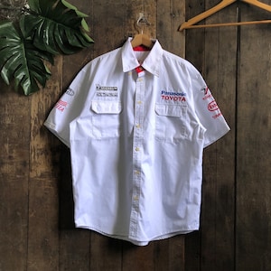 May include: White short-sleeved button-down shirt with various sponsor logos, including Michelin, Panasonic Toyota, and Toyota.
