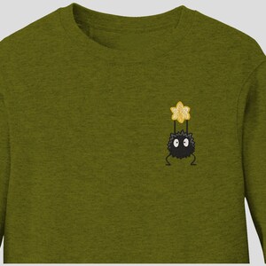 May include: A green long-sleeved sweatshirt with an embroidered black and yellow character from the movie 'My Neighbor Totoro'.