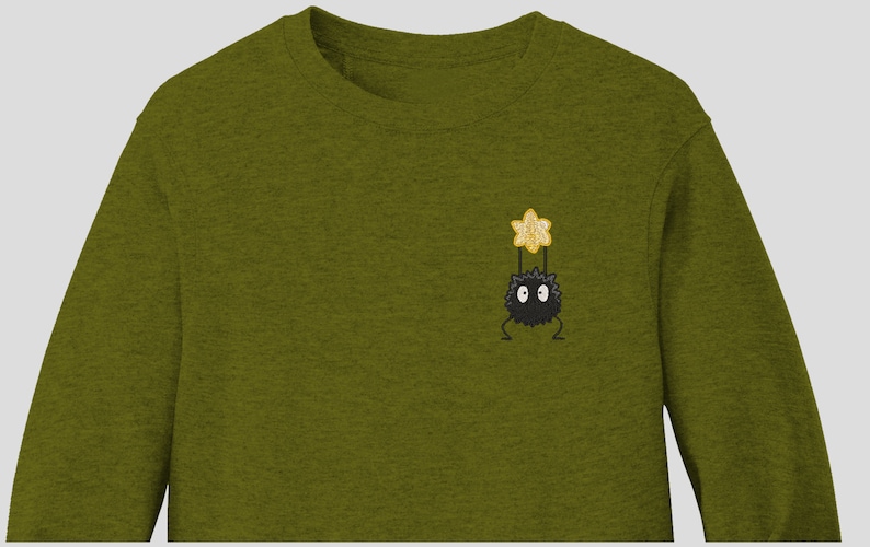 May include: A green long-sleeved sweatshirt with an embroidered black and yellow character from the movie 'My Neighbor Totoro'.