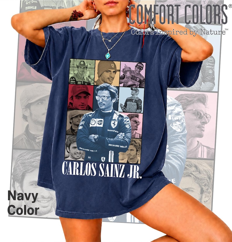 Peut inclure: Un t-shirt bleu marine pr&eacute;sentant un collage de neuf portraits photographiques de Carlos Sainz Jr. dans divers contextes de course. Le texte "CARLOS SAINZ JR." est imprim&eacute; en blanc au bas du graphique. Le t-shirt a un col rond et des manches courtes.