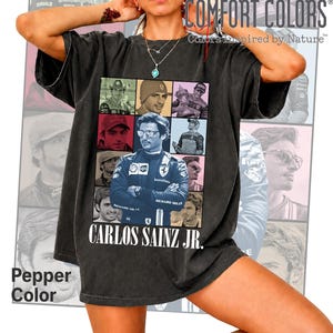 Peut inclure: Un t-shirt gris anthracite &agrave; manches courtes pr&eacute;sentant un collage de neuf portraits photographiques du pilote de course Carlos Sainz Jr. L'image centrale montre le pilote en combinaison. Le texte "CARLOS SAINZ JR." est imprim&eacute; en blanc.
