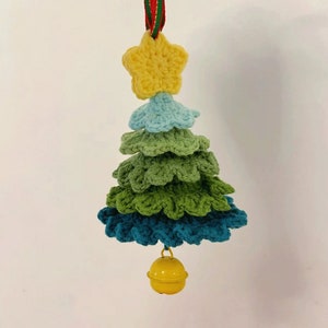 May include: A crocheted Christmas tree ornament with a yellow star on top and a yellow bell at the bottom. The tree is made of layers of green, blue, and light blue yarn.