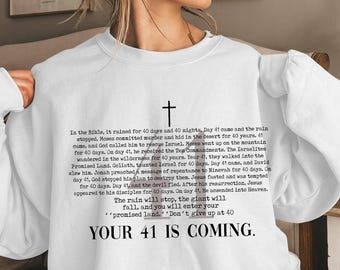 May include: White crewneck sweatshirt with a black cross graphic and text. The text includes biblical references to the number 40 and the phrase "YOUR 41 IS COMING."
